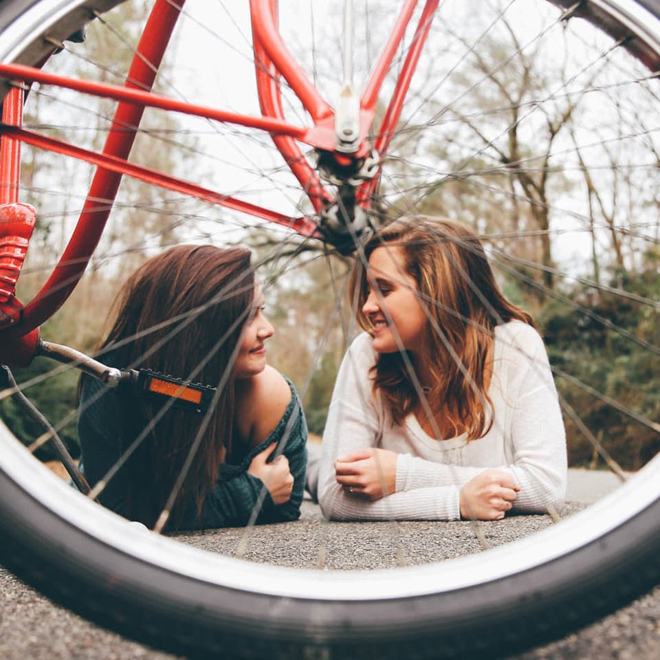 Two friends through a bike wheel